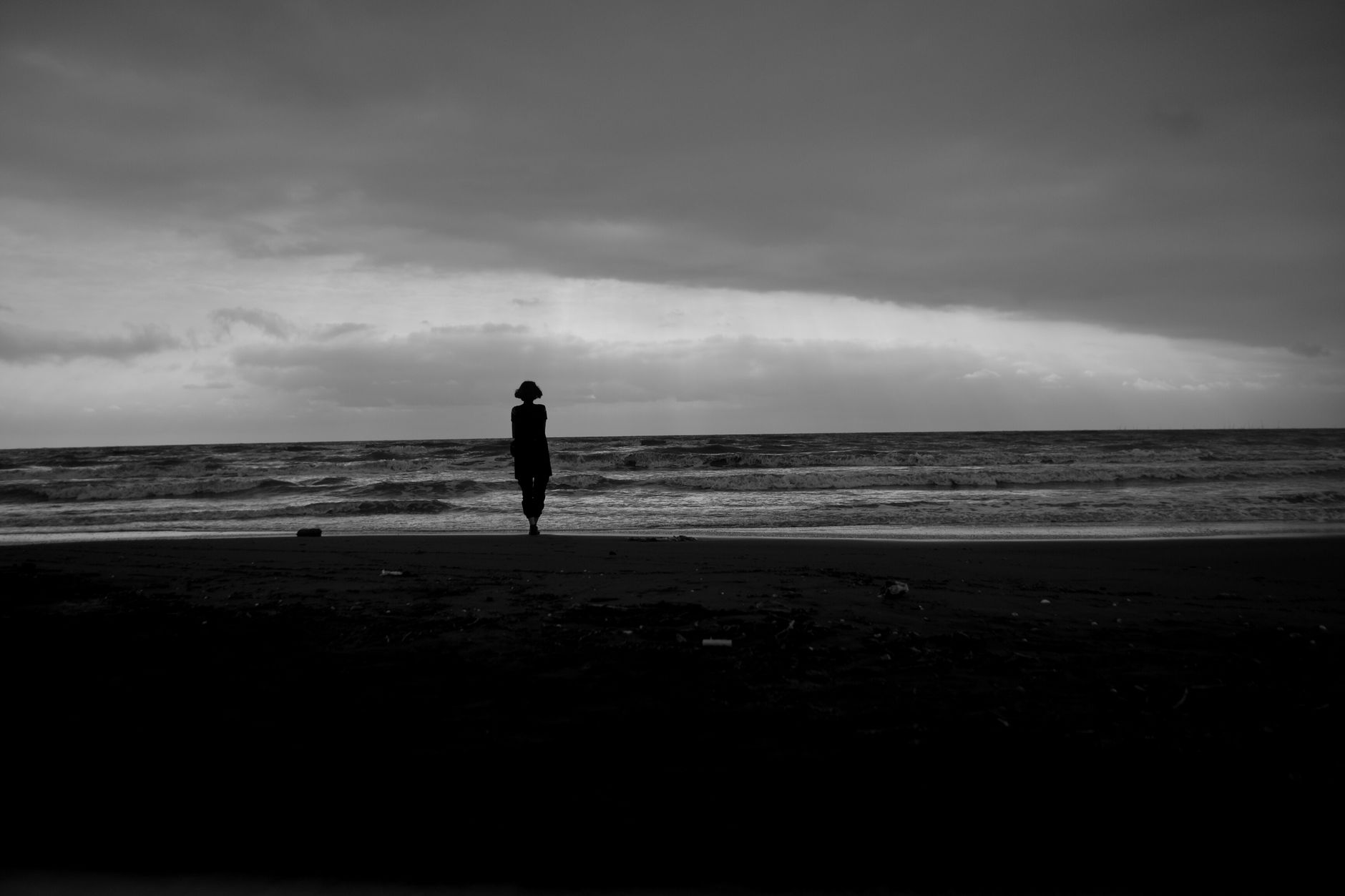 silhouette of a person standing on shore